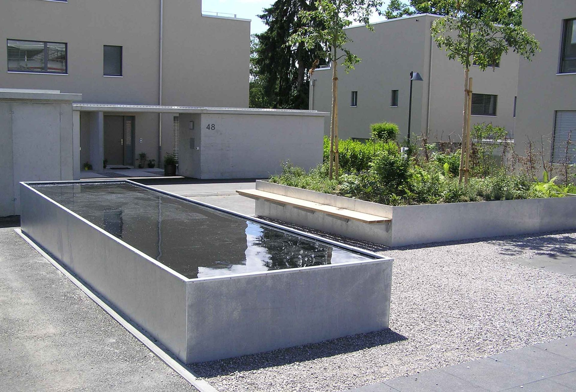 Bassin rectangulaire surélevé avec banc dans une cour résidentielle