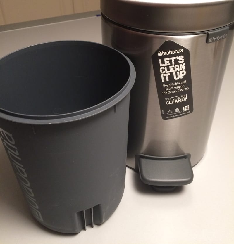 Poubelle Brabantia avec l’étiquette « Let's clean it up » en faveur de The Ocean Cleanup, à côté de son seau intérieur en plastique retiré