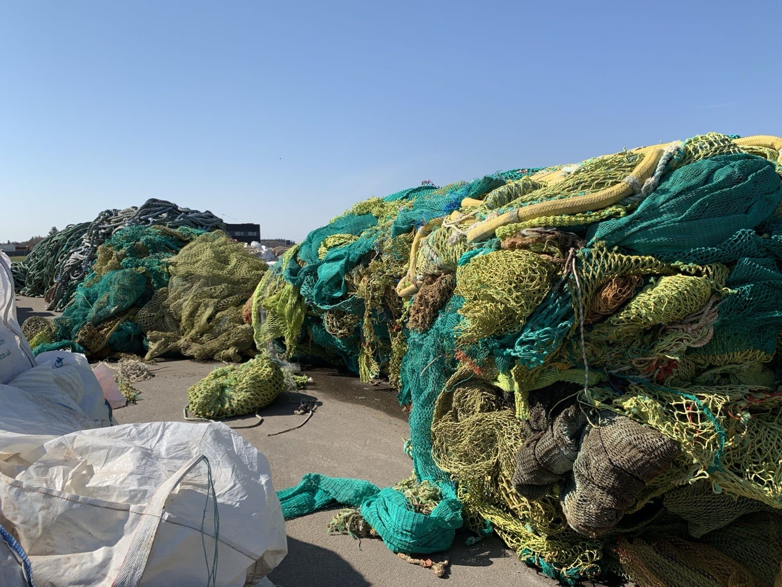 Piles of discarded plastic fishing nets at a collection yard