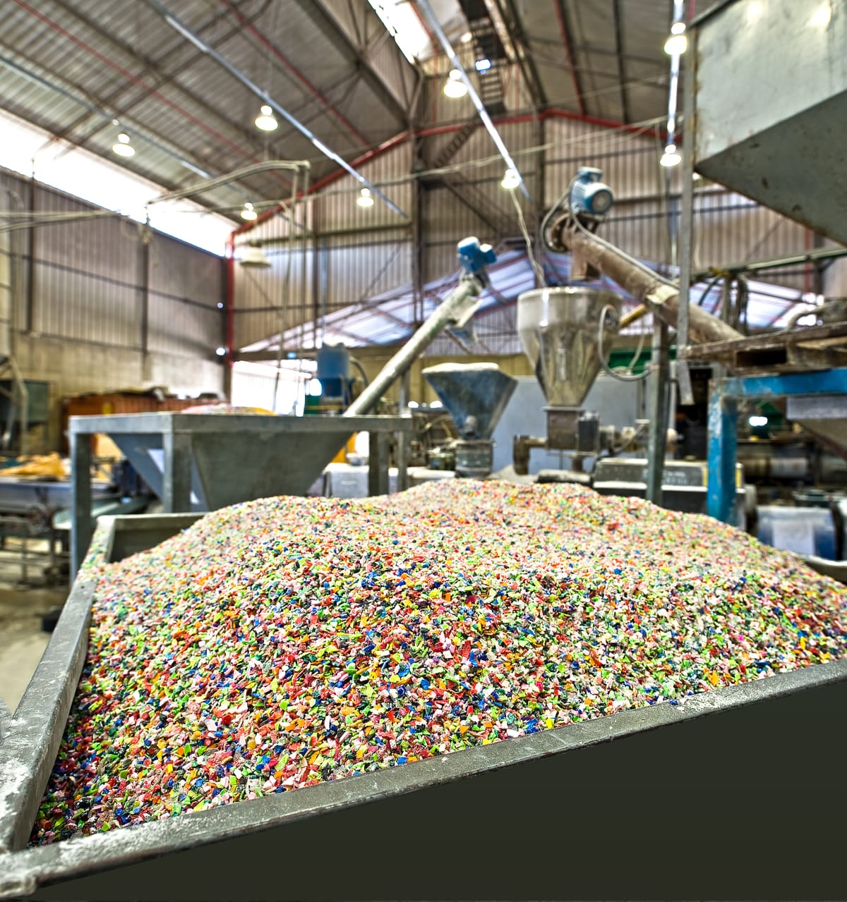 Colourful plastic regrind in a container in a recycling plant