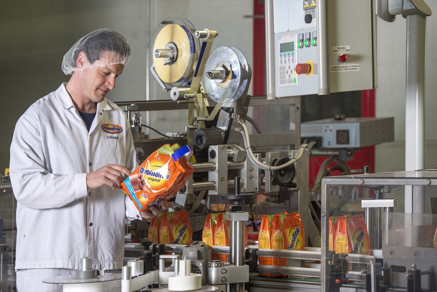 Mitarbeiter an der Abfüllanlage mit Ovomaltine-Beuteln in der Produktion
