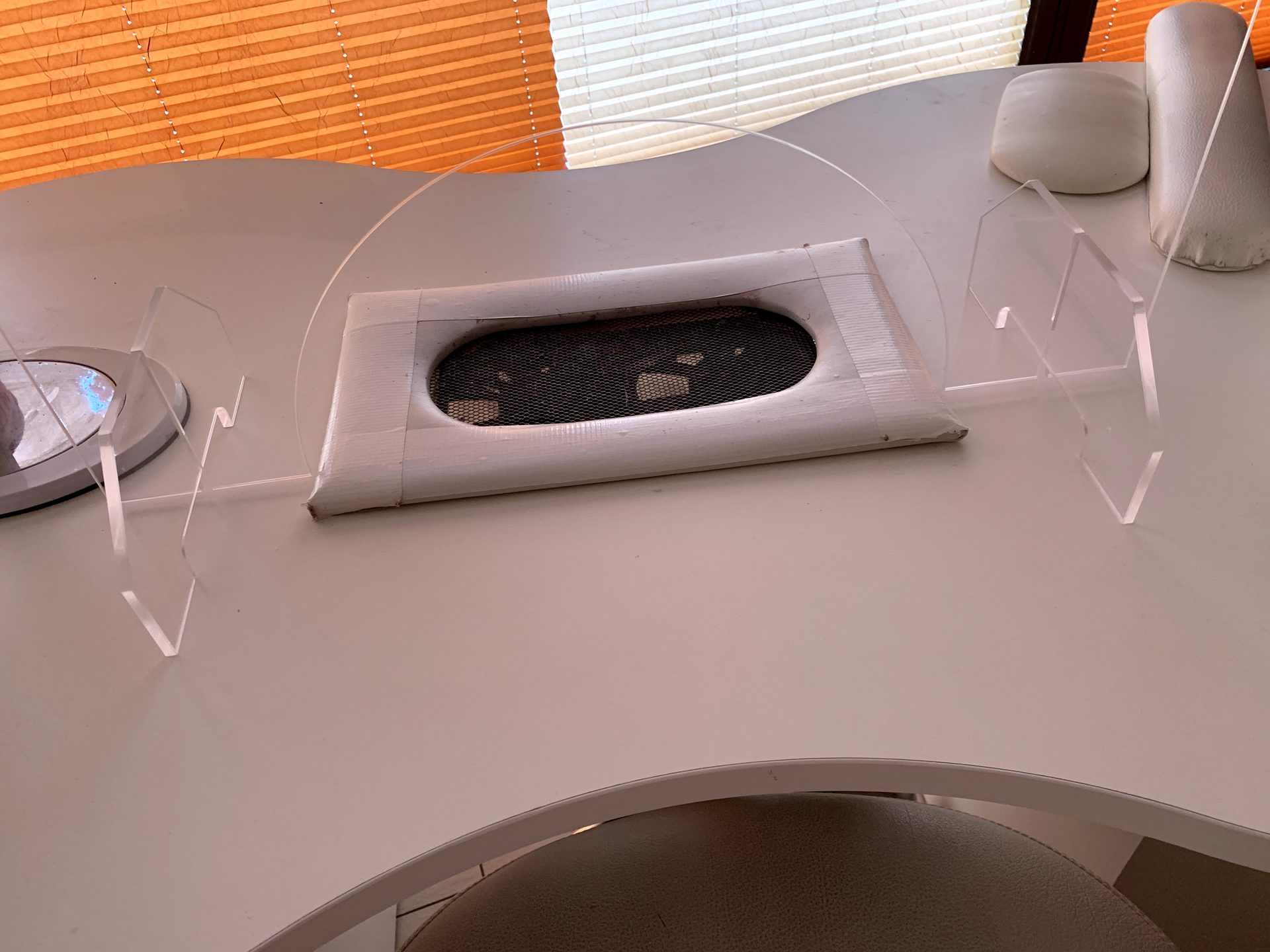 Sneeze guard with widened pass-through on a nail table in the studio