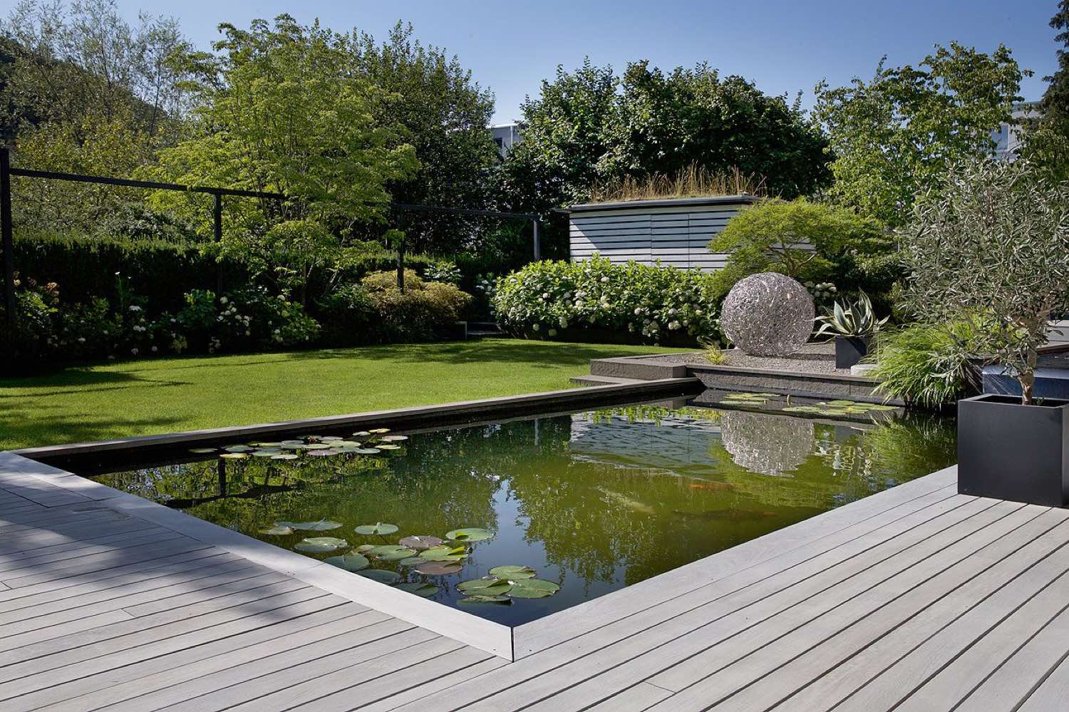 Basin with adjoining lawn, clipped shrubs and terrace