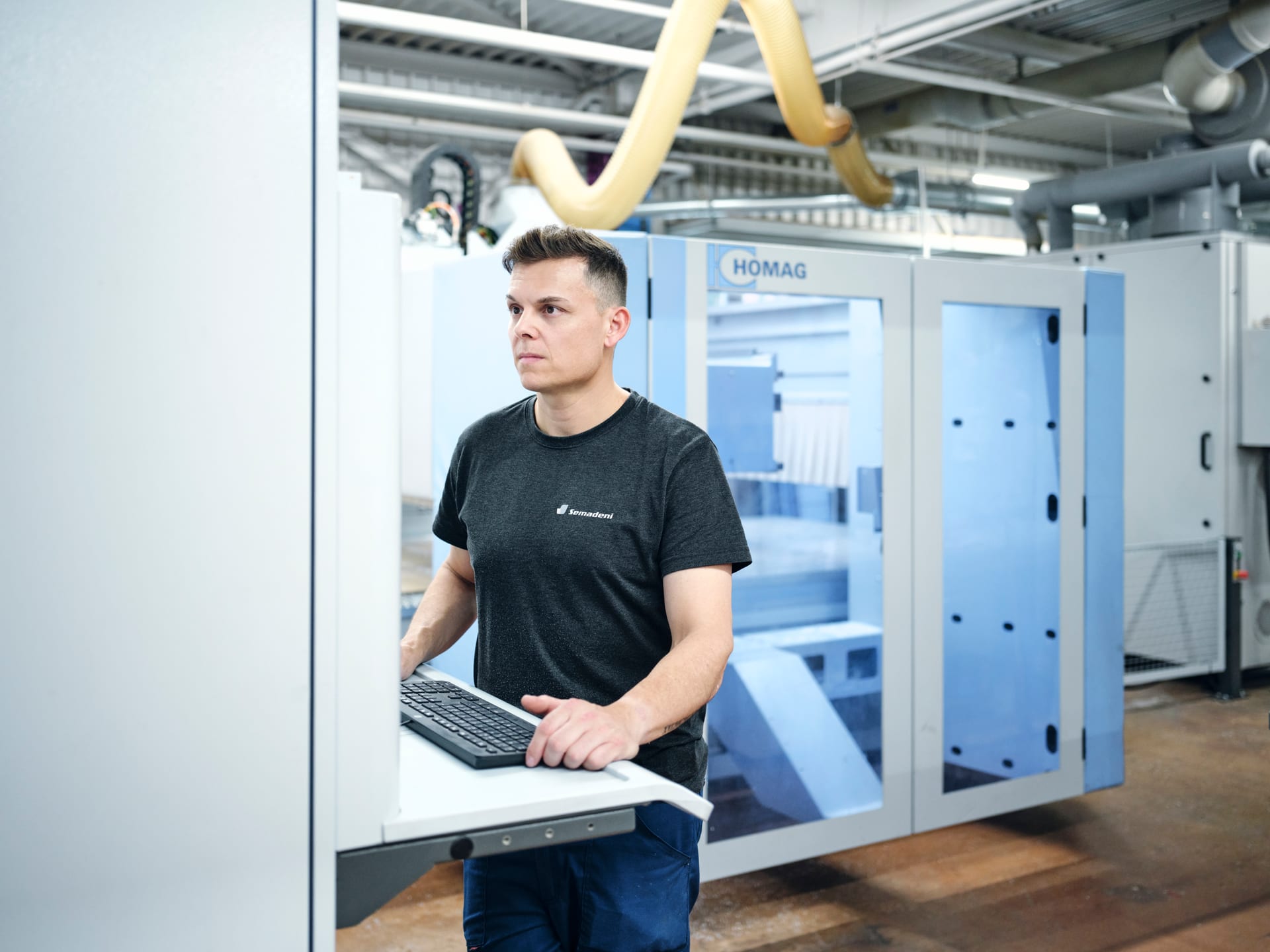 Mitarbeiter am Bedienpult einer CNC-Fräse in der Kunststoffbearbeitung