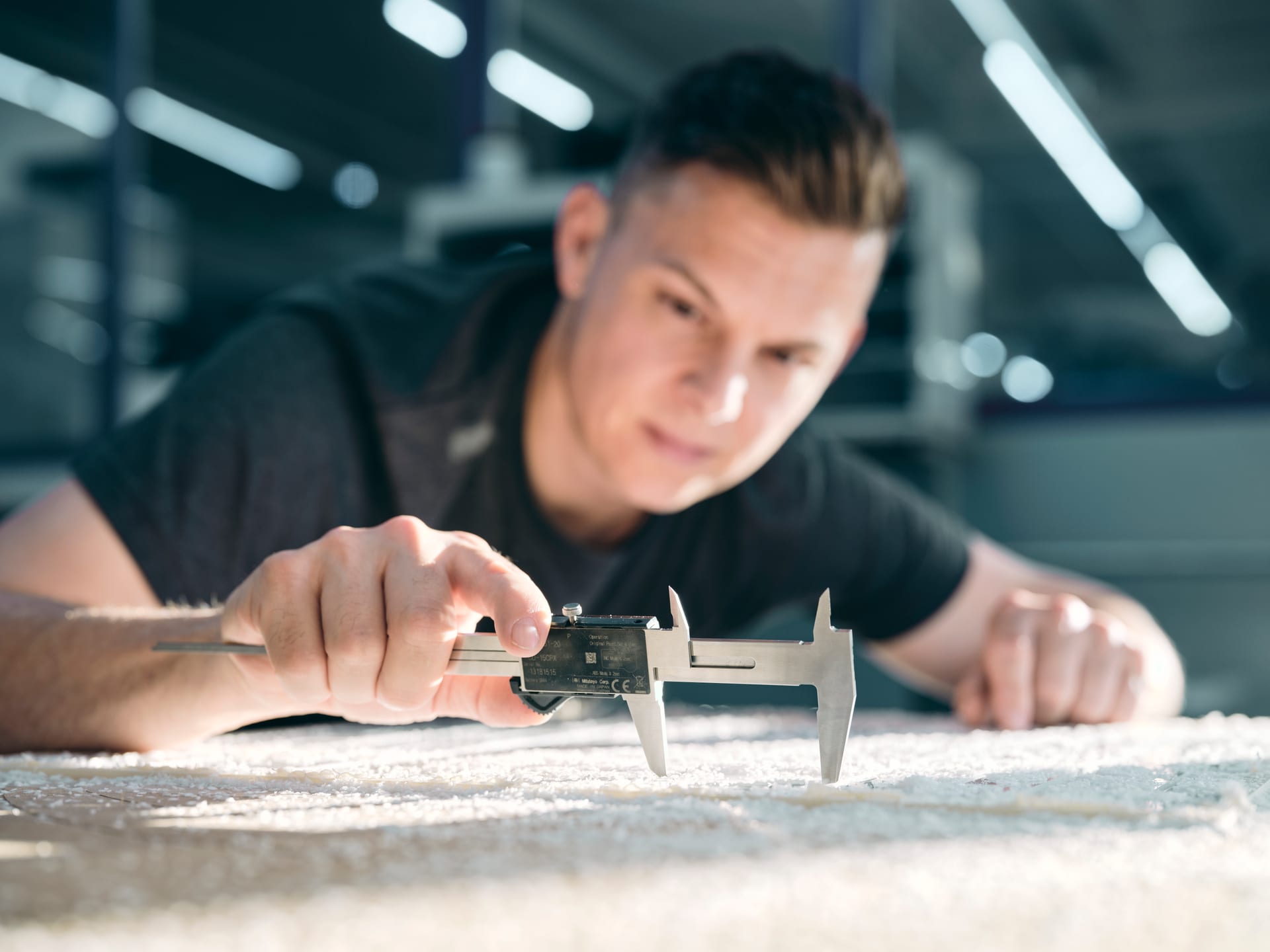 Young employee checks a dimension with a caliper
