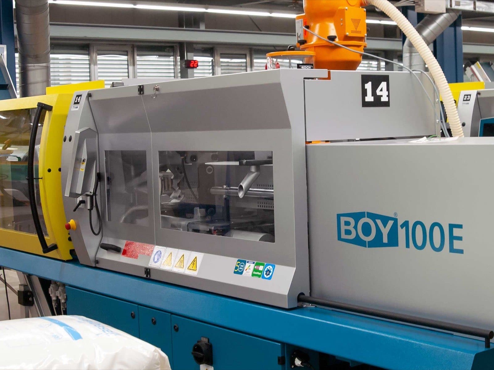 BOY 100E injection moulding machine with material hopper on the shop floor